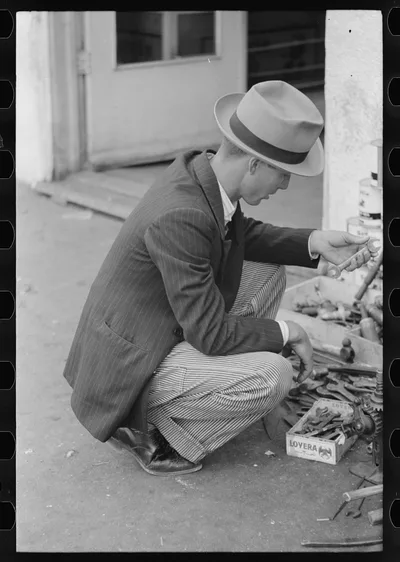 Man looking at wrench, market square, Waco, Texas, 1939