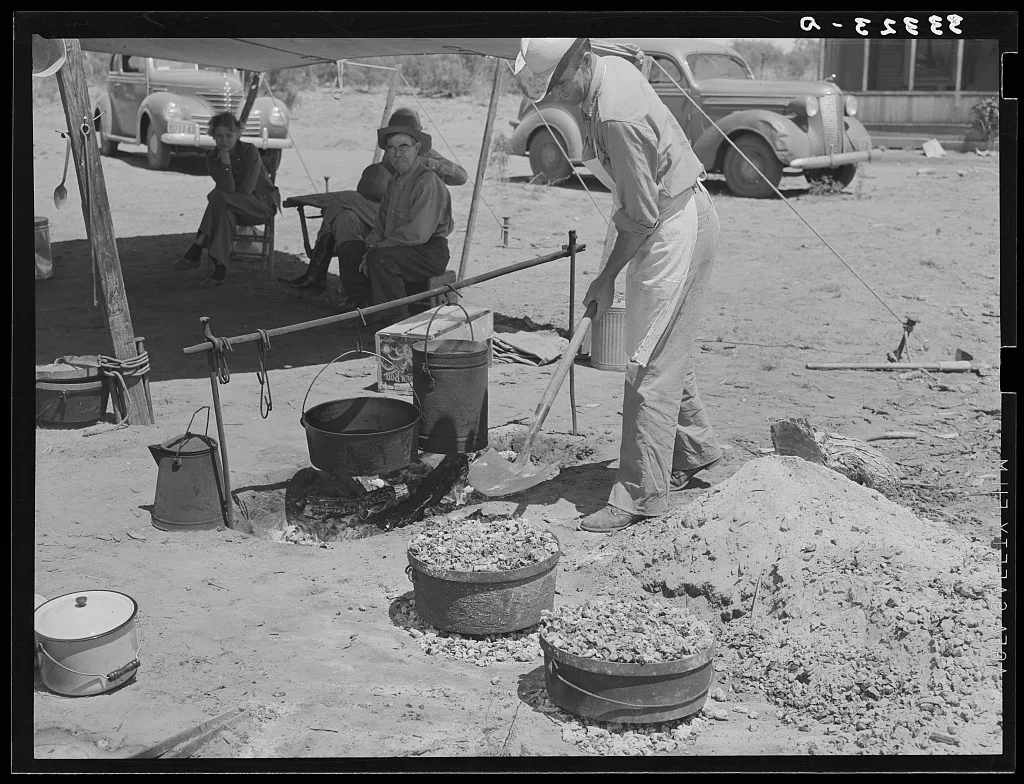 Cook of SMS Ranch making bread in front of chuck wagon. Ranch near…, 1939
