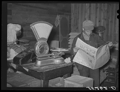 Farmer reading newspaper in feed and general produce store. Eufaula,…, Oklahoma, 1940