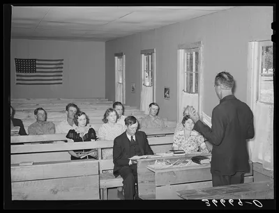 Mr. Whinery, homesteader and licensed preacher, reading the Sunday…, New Mexico, 1940