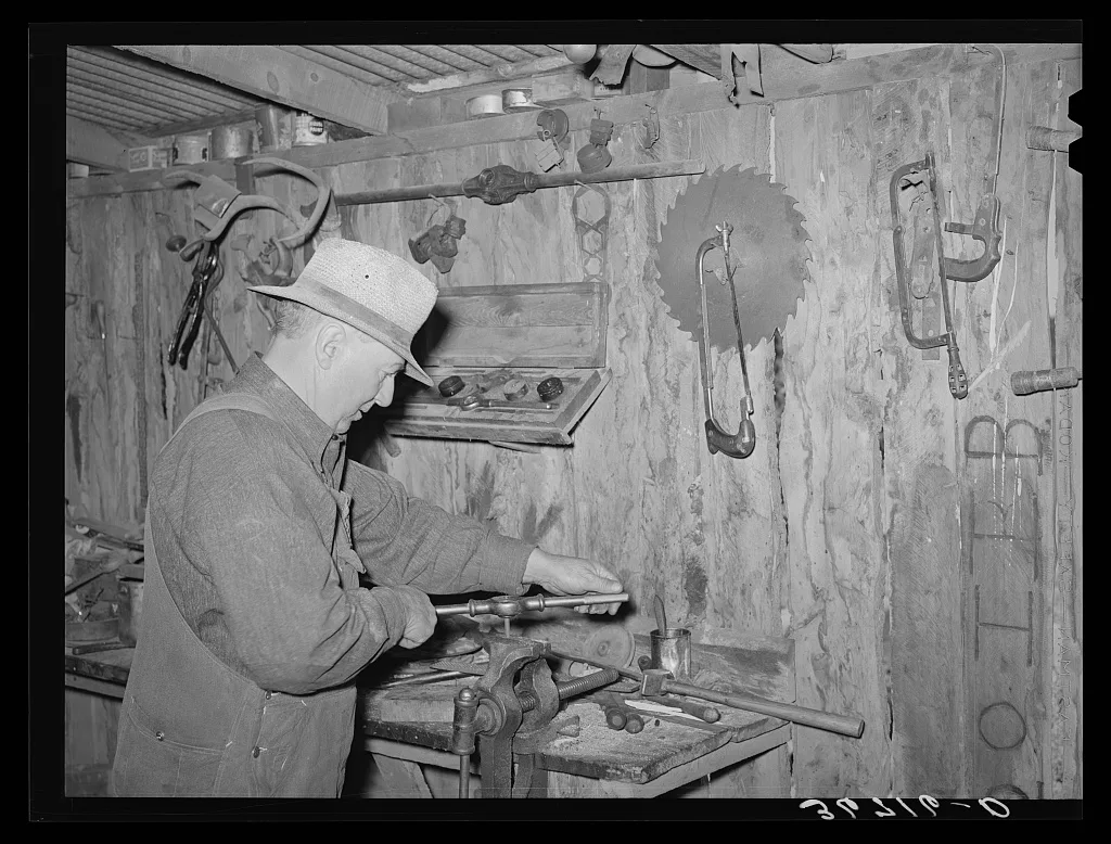 George Hutton Sr., in the machine shop on his farm. Pie Town, New…, New Mexico, 1940
