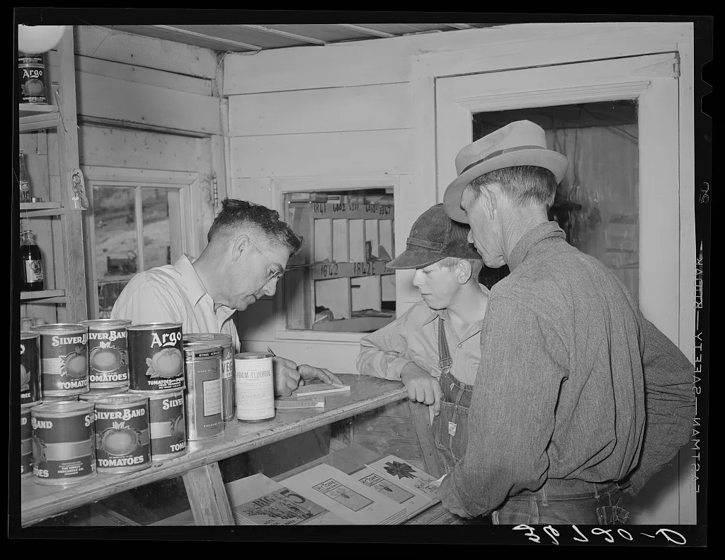 Mr. Keele, merchant and president of the Farm Bureau, making out bill…, New Mexico, 1940