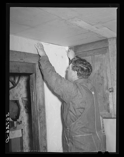 George Hutton, Jr., papering the kitchen for his mother. Pie Town,…, New Mexico, 1940