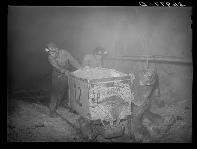Pushing a car load of gold ore along track in mine. Mogollon, New…, New Mexico, 1940