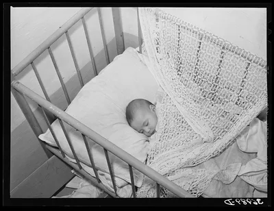 Spanish-American baby in its crib. Chamisal, New Mexico, 1940