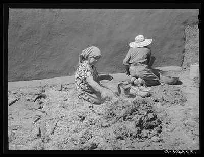 Spanish-American women making plaster of straw and mud to replaster…, New Mexico, 1940