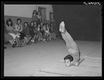 Spanish-American acrobat of traveling show. Audience in background. …, New Mexico, 1940