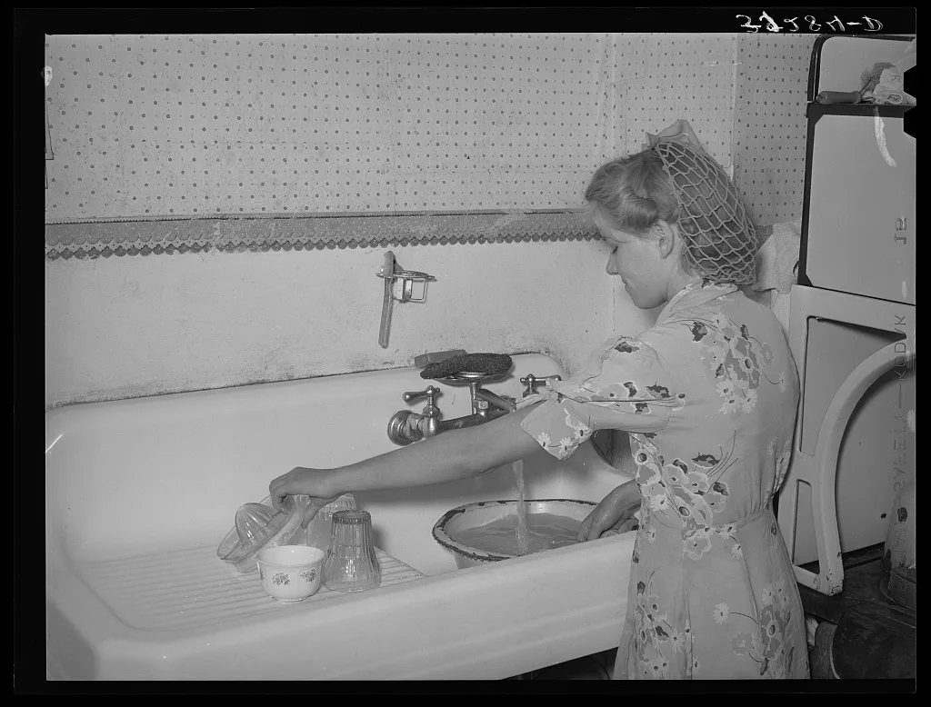 Daughter of Mormon farmer washing dishes. In most of the Mormon…, Utah, 1940