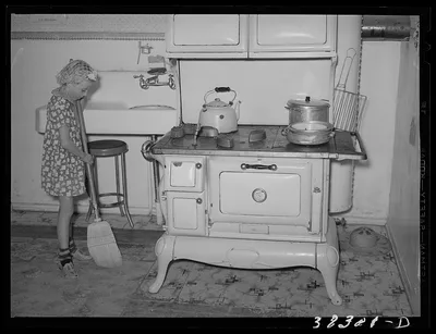 Daughter of Mormon farmer sweeping up the kitchen. Snowville, Utah, 1940