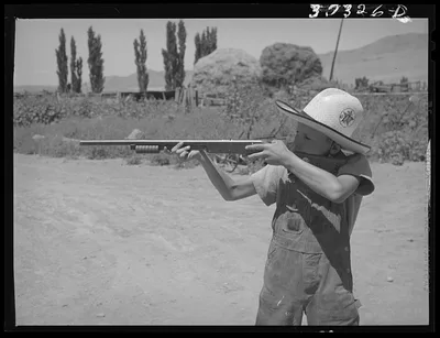 Mormon farm boy shooting air rifle. Box Elder County, Utah, 1940