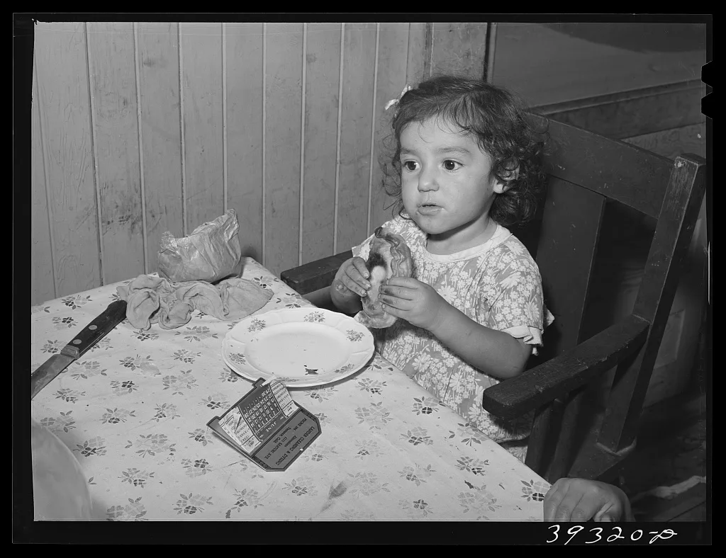 Little Mexican girl eating enchilada for lunch. San Diego, California, 1941